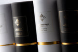 Zylinderverpackungen Raumdüfte Relax-Cottage. Der Duft Oud Nude in Schwarz-Gold und der Duft The Seduction in Weiß-Gold verpackt